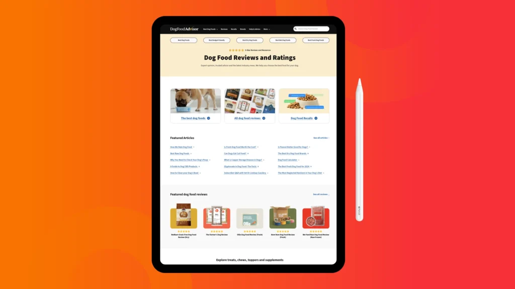 Close-up of a tablet displaying the Dog Food Advisor website, featuring reviews, ratings, and articles about dog food.