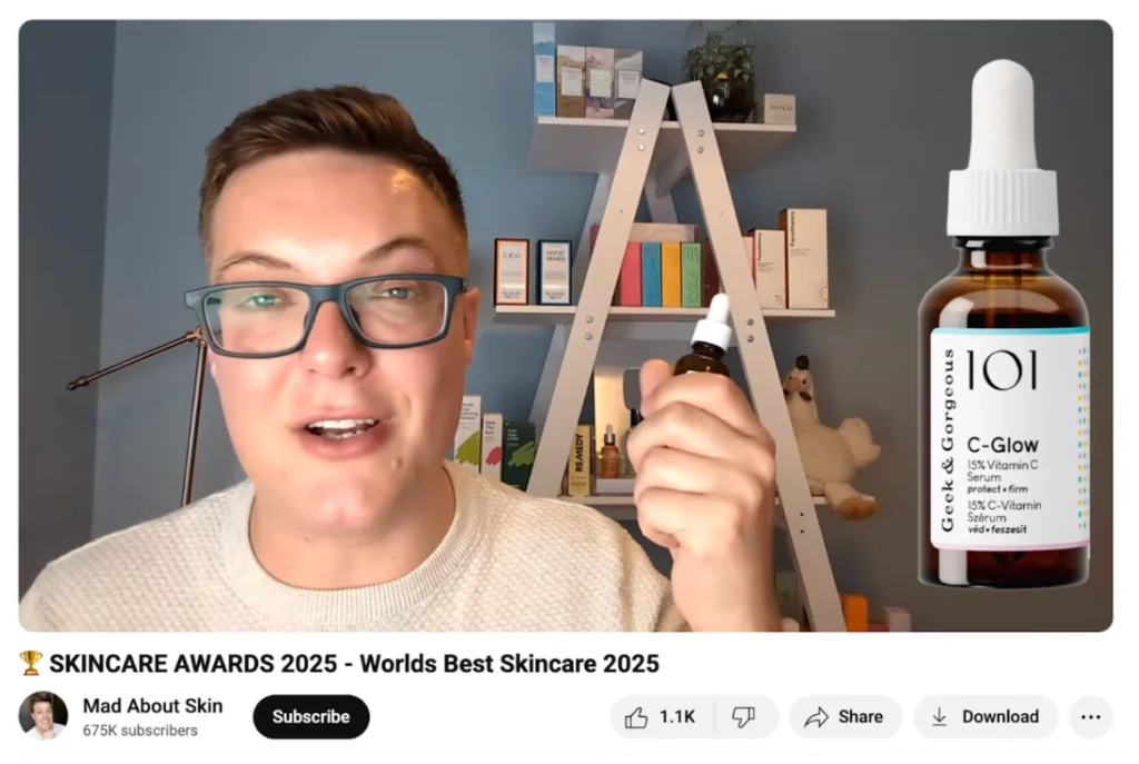 A person in a white sweater holds a dropper bottle of C-Glow serum, surrounded by colorful skincare products on a shelf.
