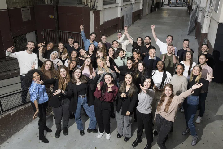 A group of individuals smiling and posing for a photograph inside a spacious industrial building.