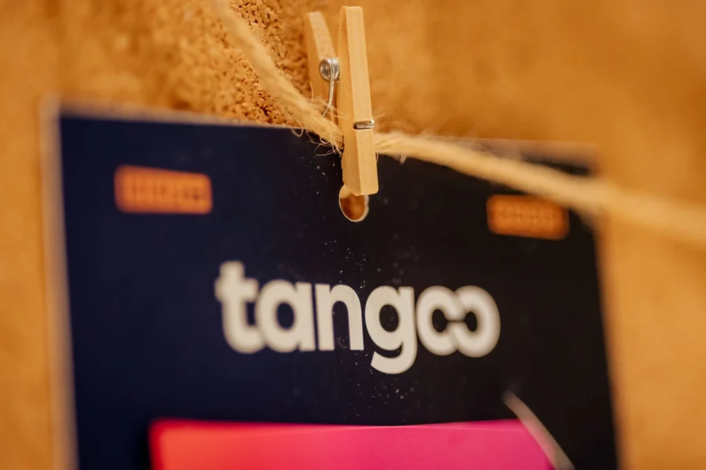Close-up of a clothespin holding a card marked "tango" on a corkboard.