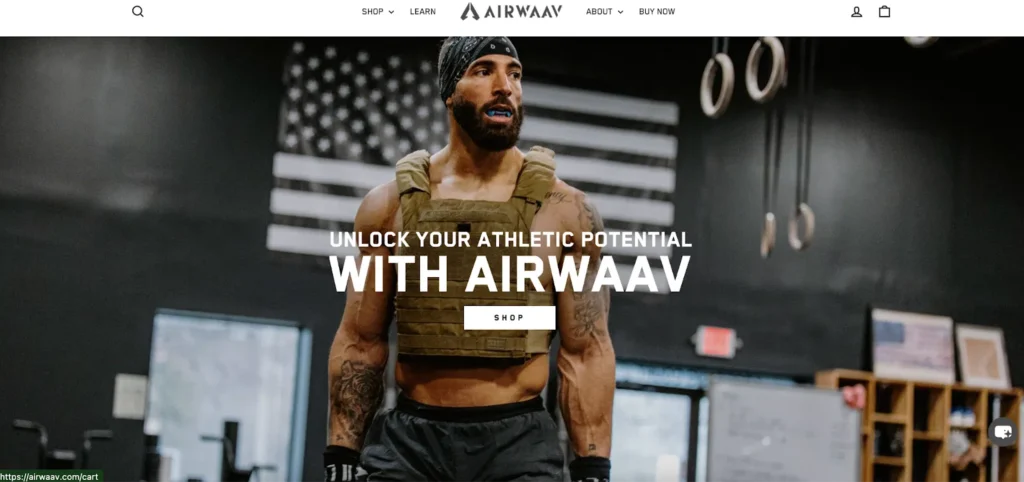 An athletic individual in a weighted vest stands in a gym, surrounded by fitness equipment and an American flag backdrop, promoting Airwaav.