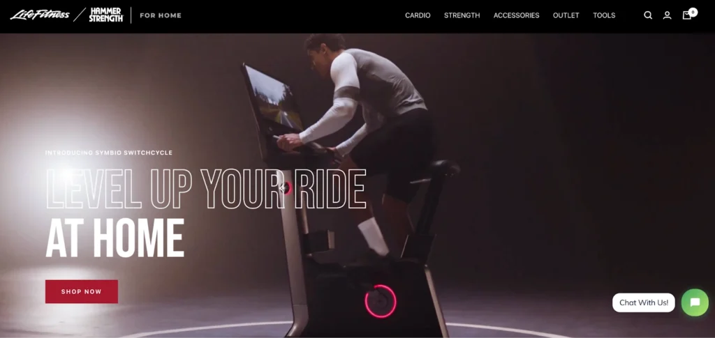 A person is riding a modern exercise bike featuring a digital screen, set against a dark background. The scene emphasizes home fitness.