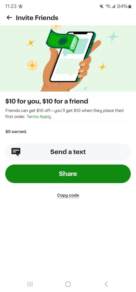 A hand holding a smartphone displays an invitation to earn $10 by referring friends for their first order.