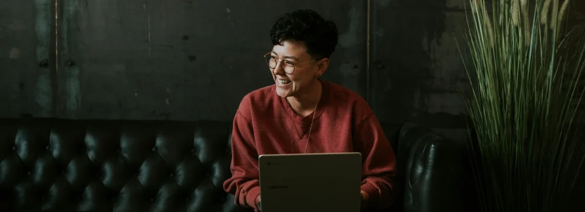 woman smiling whilst holding laptop