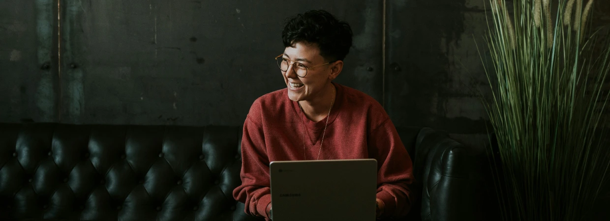 woman smiling whilst holding laptop