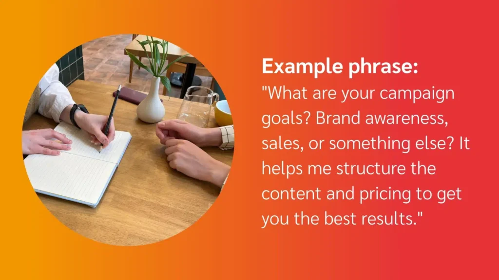 A person writing in a notebook while discussing campaign goals, with a plant and a drink in the background, exemplifying collaborative planning.