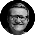 A person with short, light-colored hair is positioned against a dark background, creating a stark contrast.