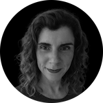 A portrait of a person with wavy, shoulder-length hair against a solid black background. The image is focused on the hair and upper body.